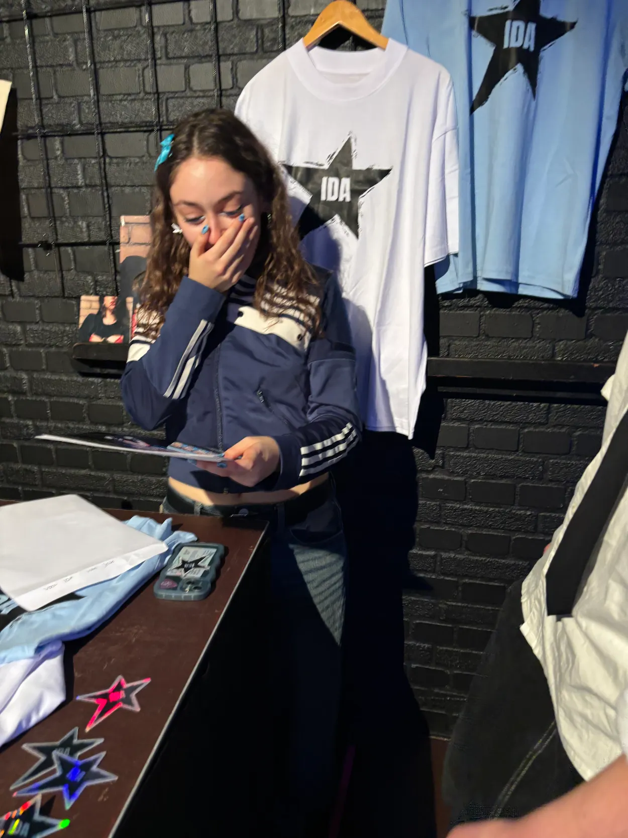 Ida Weiler bekijkt verrast de tekening van Jelle bij de merchandise stand